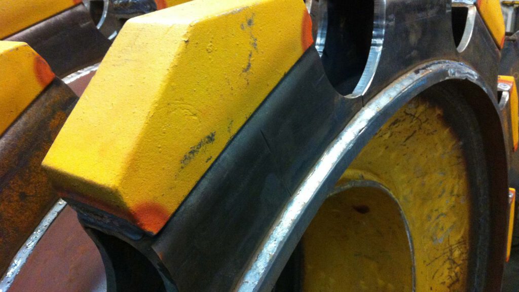 Refurbished soil compactor wheel with Macpactor pads